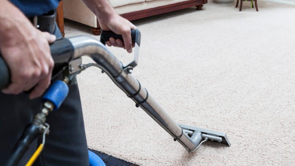Professional Cleaning & Home Services in Holladay, Utah - Father and Son Carpet Cleaning A person uses a carpet cleaning machine to refresh a light-colored carpet in a Holladay, Utah living room, showcasing professional home and cleaning services.