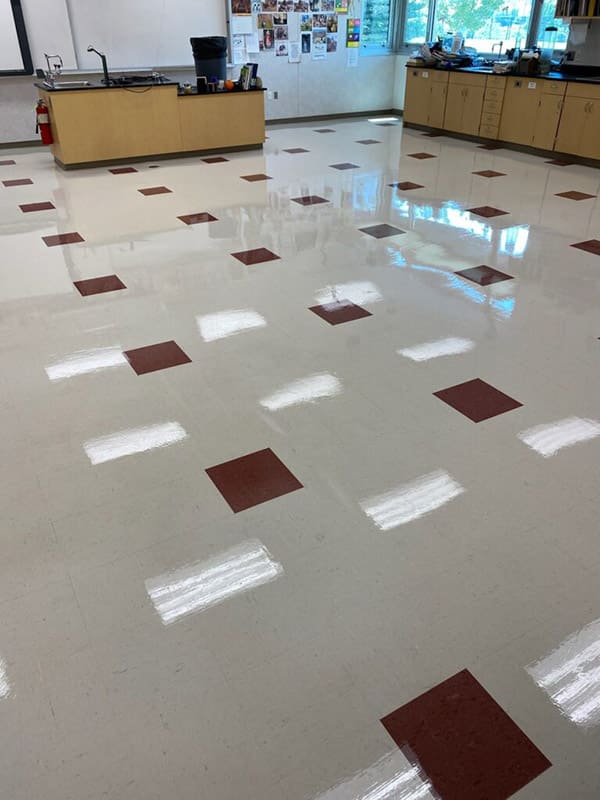 A classroom with red and white squares on the floor, enhanced by professional VCT Strip and Wax Services
