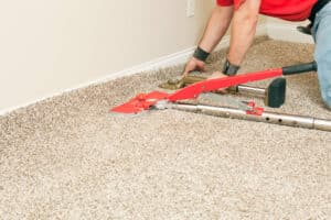 A man using a tool for carpet installation near Salt Lake City.