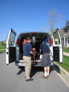 Two carpet cleaners standing in the back of a van near Salt Lake City.